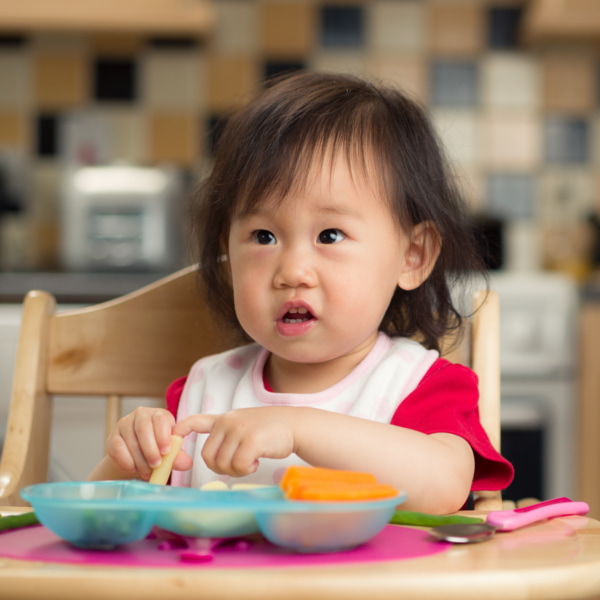 toddler eating at a table