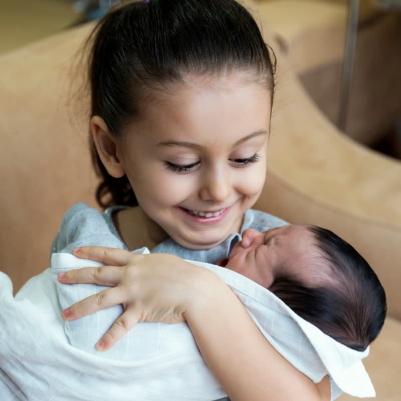 Photo of toddler holding baby