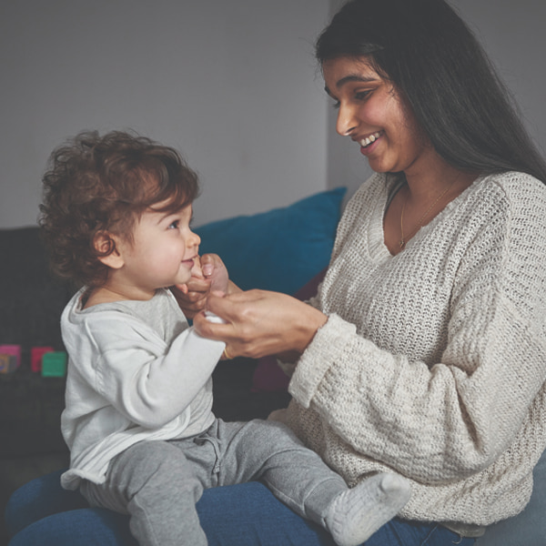 Photo of a mum and toddler playing on the couch 