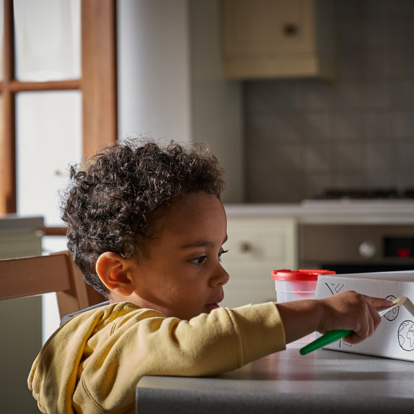 Photo of a toddler painting a baby box lid 